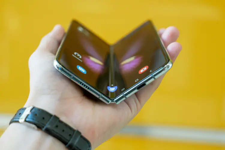 A photo of a foldable phone in a persons hand. Photo by Mika Baumeister on Unsplash