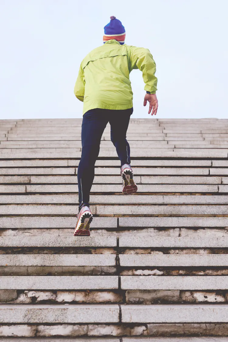 A photo of a man running up some stairs training to be a runner 