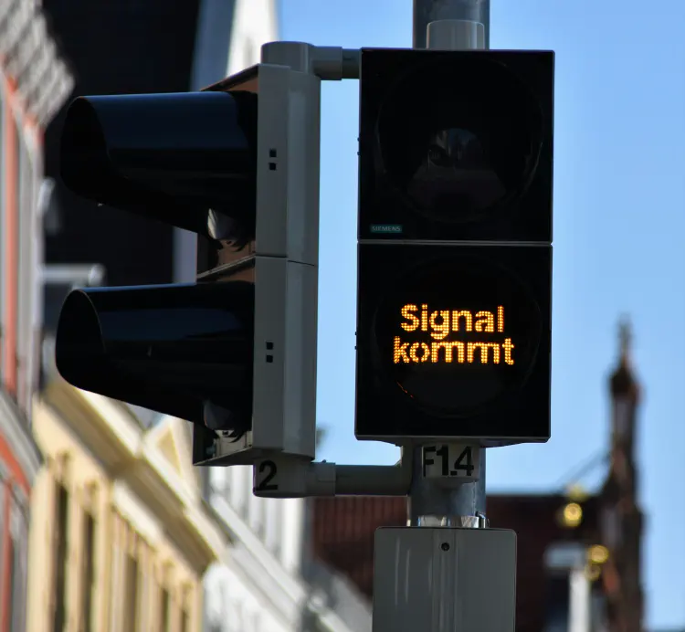 A close up of a traffice light that says Signal kommt